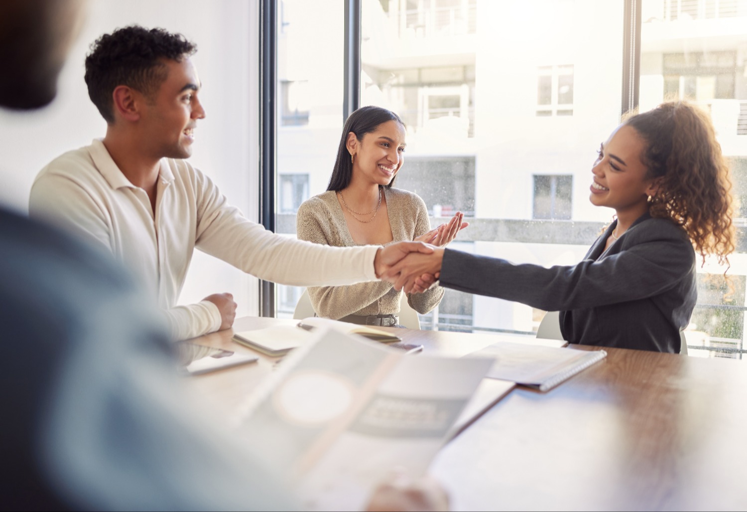 Group of three people talking and shaking hands