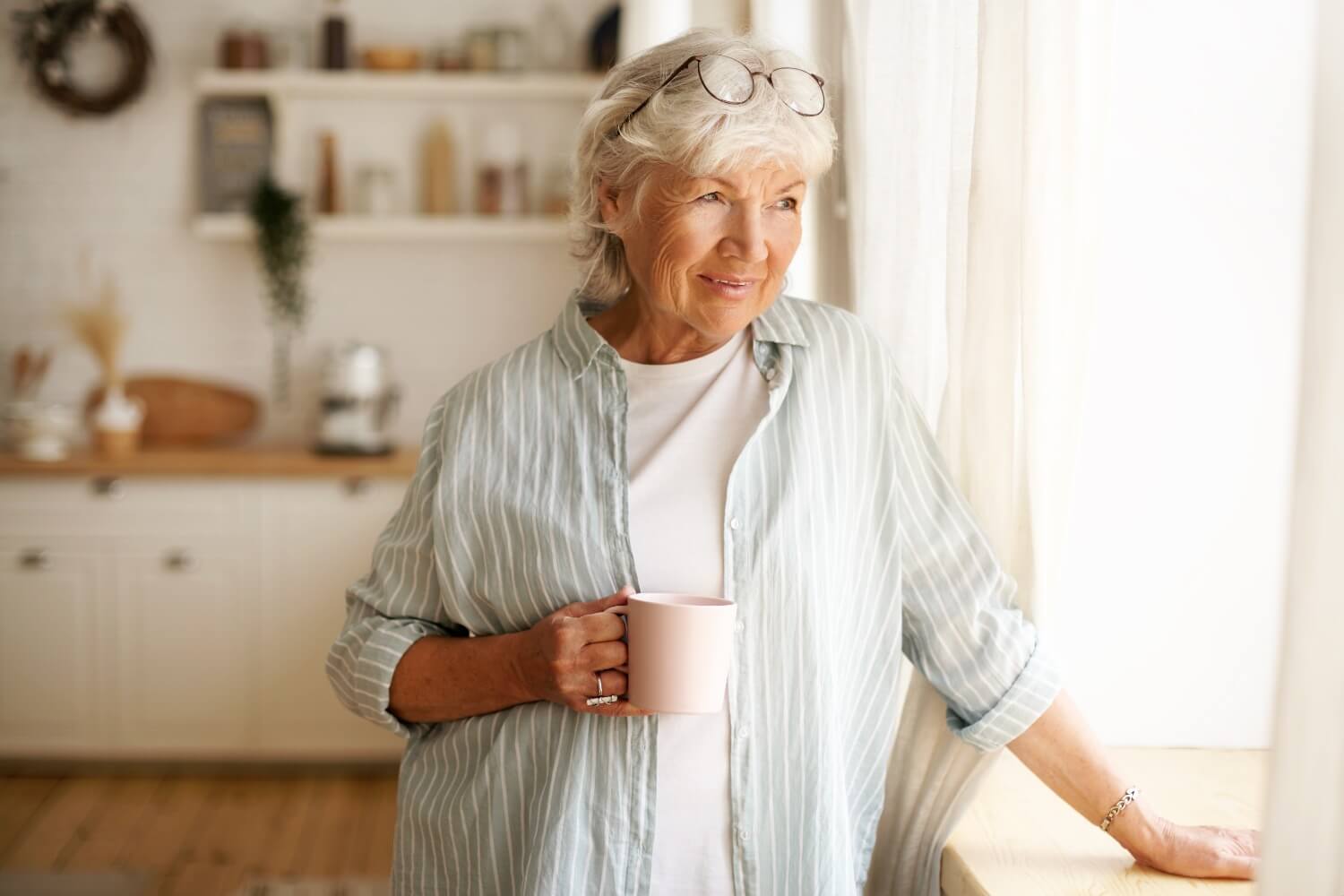 Senior woman looking off to the right with coffee