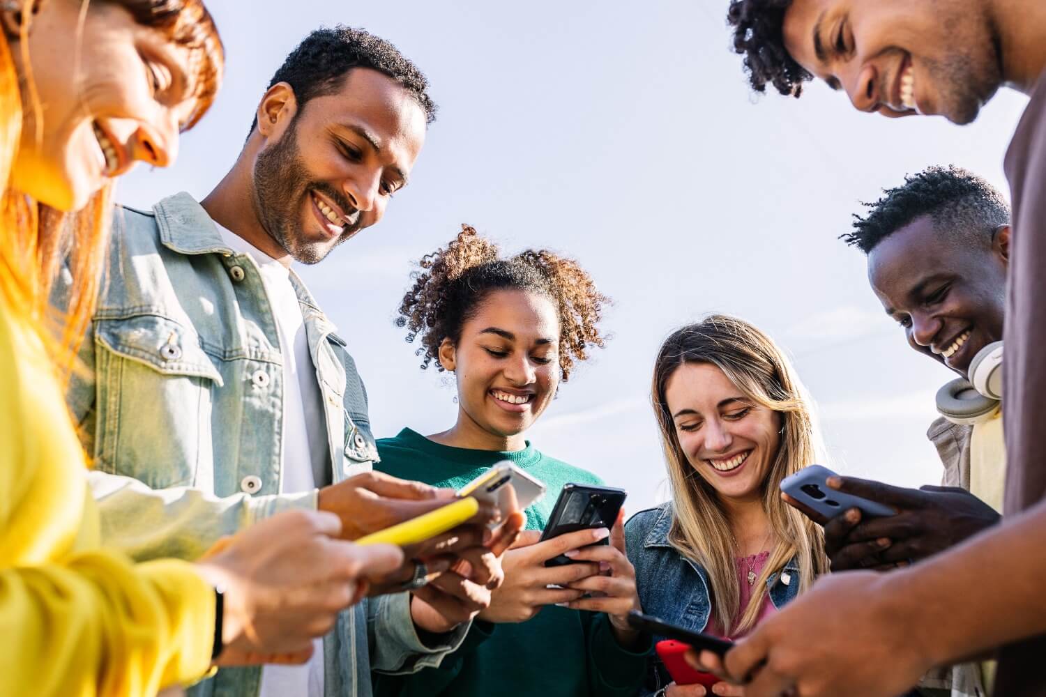 Smiling group of people using phones